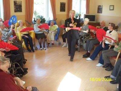 Senioren Fächer TaiJi im Altenheim Curanum Mönchengladbach, auch im Sitzen gehrt Tai Chi.